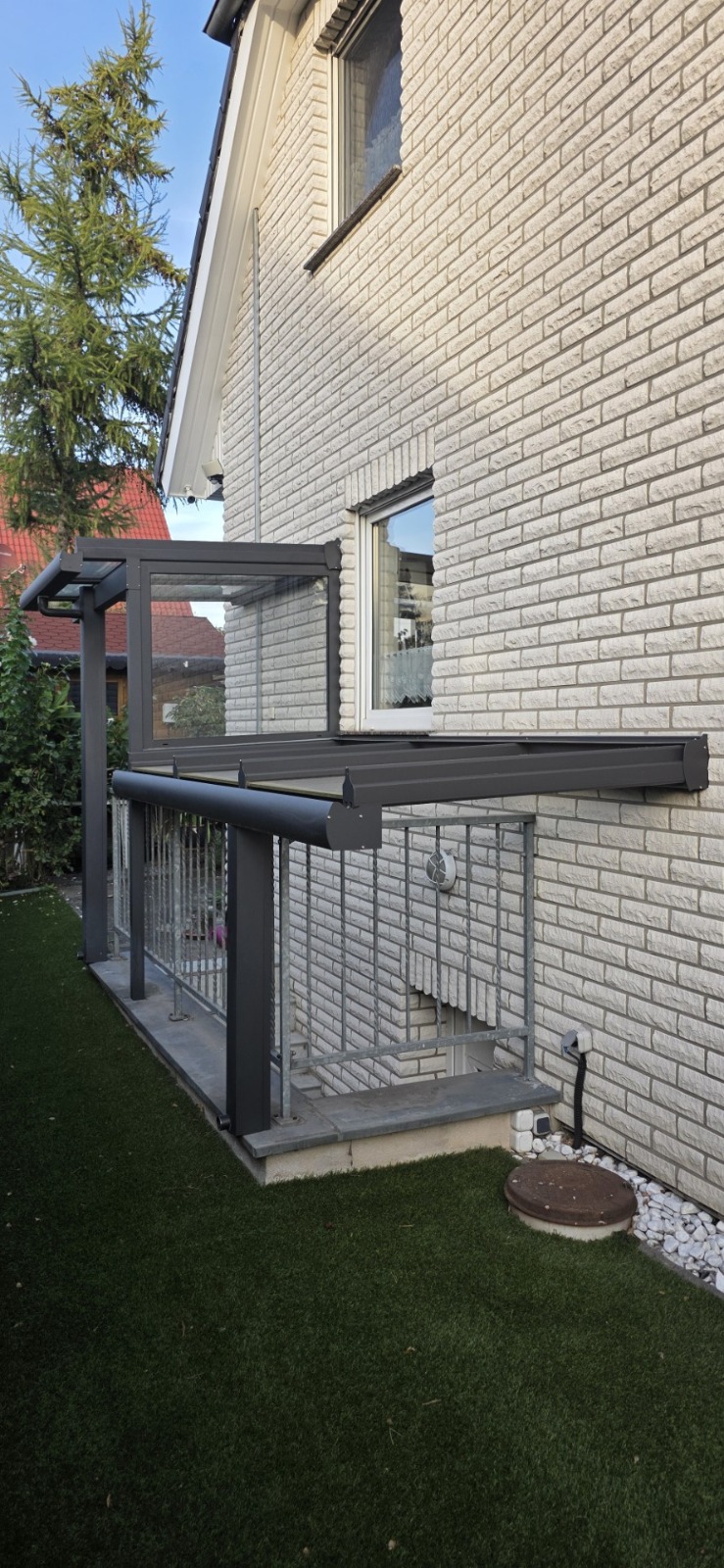 Kellerabgangsüberdachung in DB 703 vor einer hellen Klinkerfassade in Berlin-Mahlsdorf
