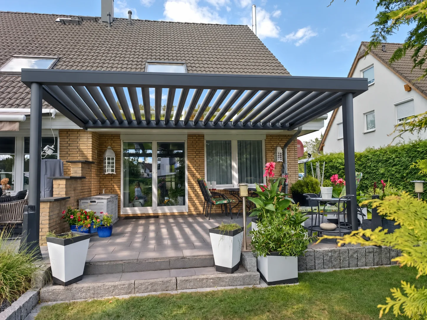 KI-Entwurf auf eigener Fotobasis: geöffnetes Lamellendach mit gleichem Haus und Garten