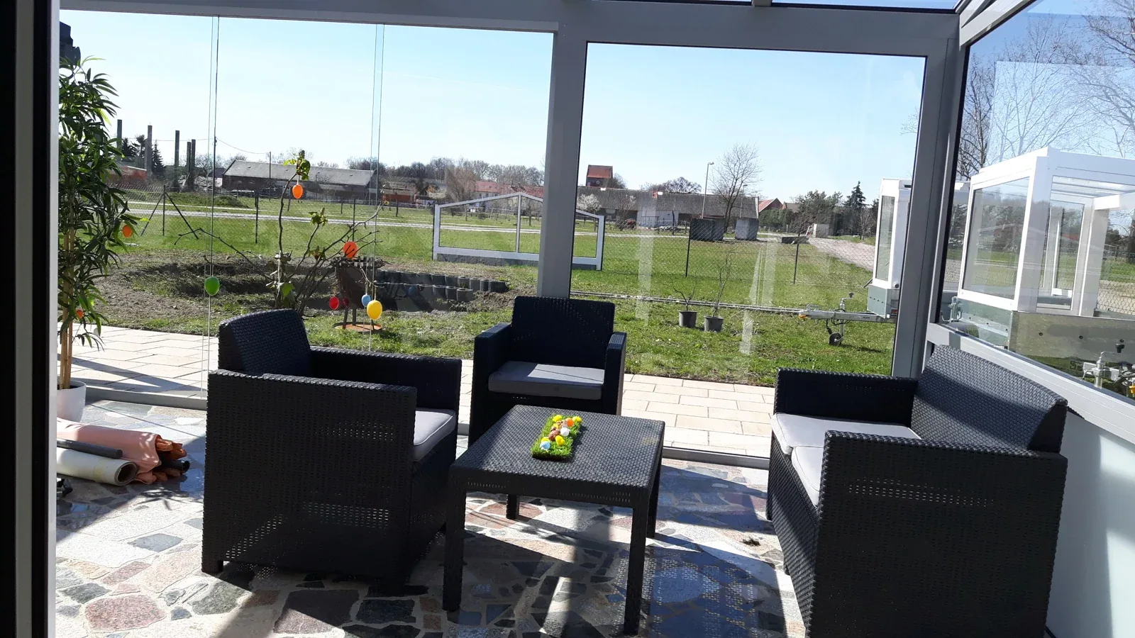 Loungebereich mit Glas-Seitenelementen und Blick in den Garten aus dem eigenen Bildbestand