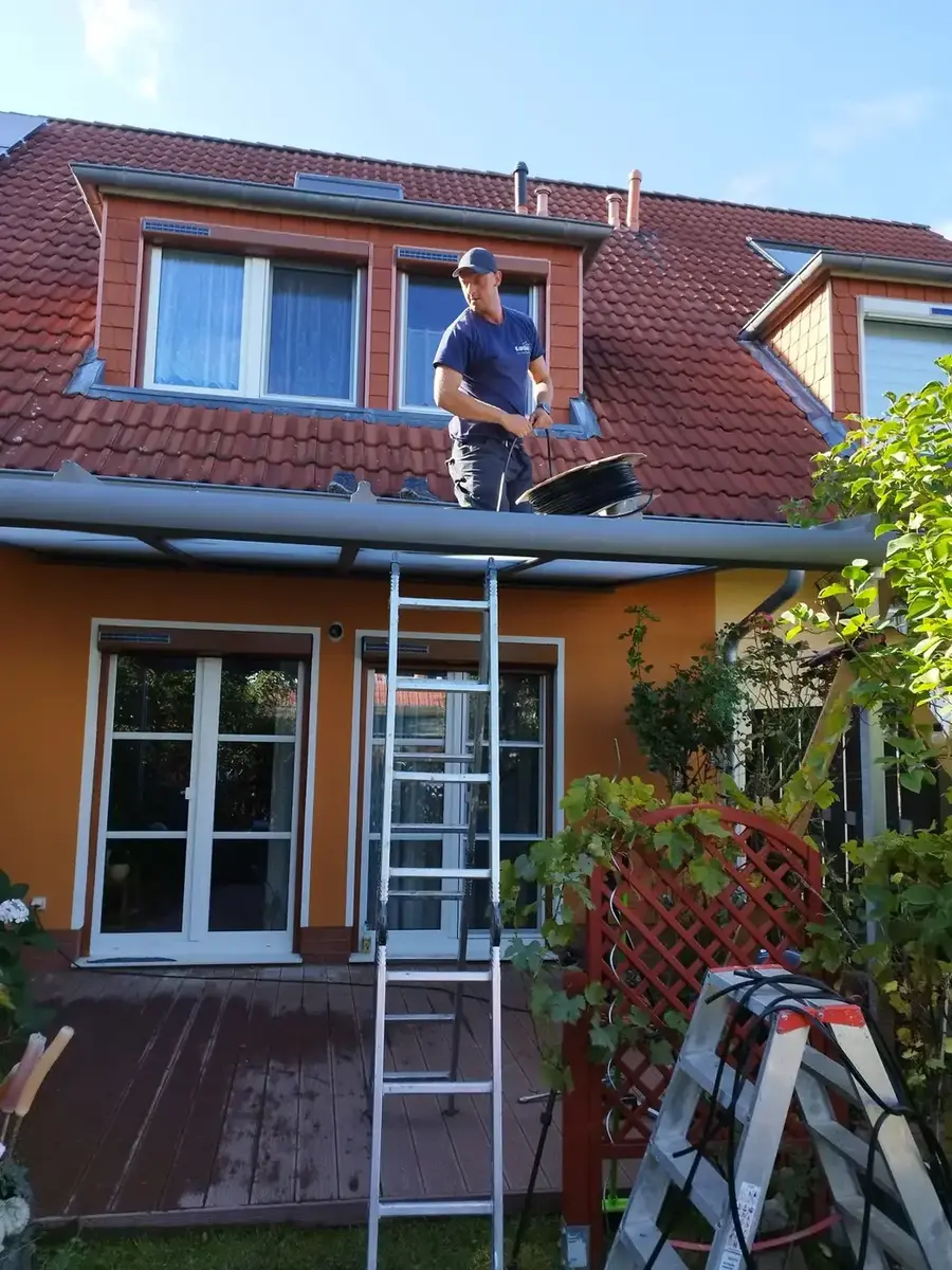 Monteur richtet die Verglasung am Terrassendach aus