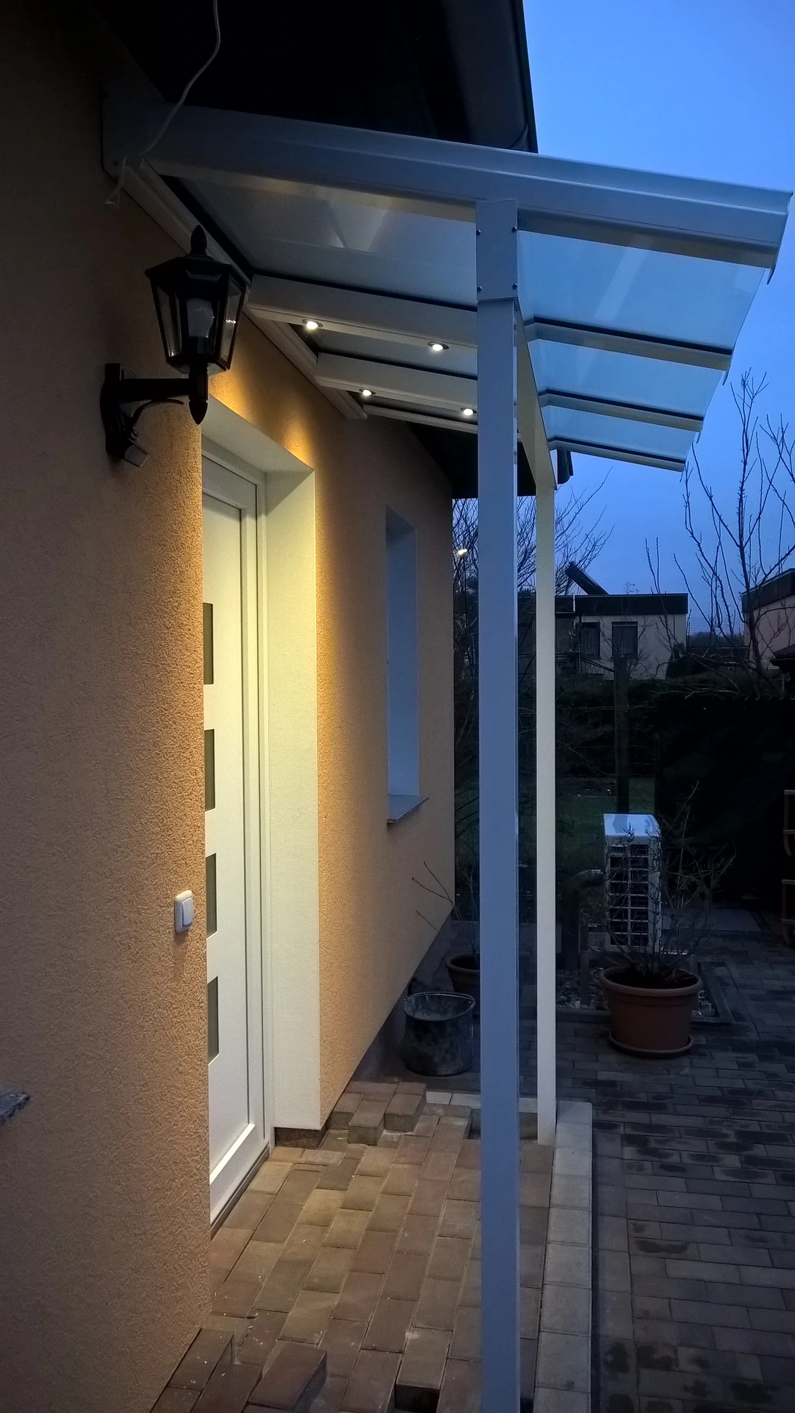 Seitliche Ansicht der Eingangsüberdachung mit LED-Spots und verglastem Seitenteil