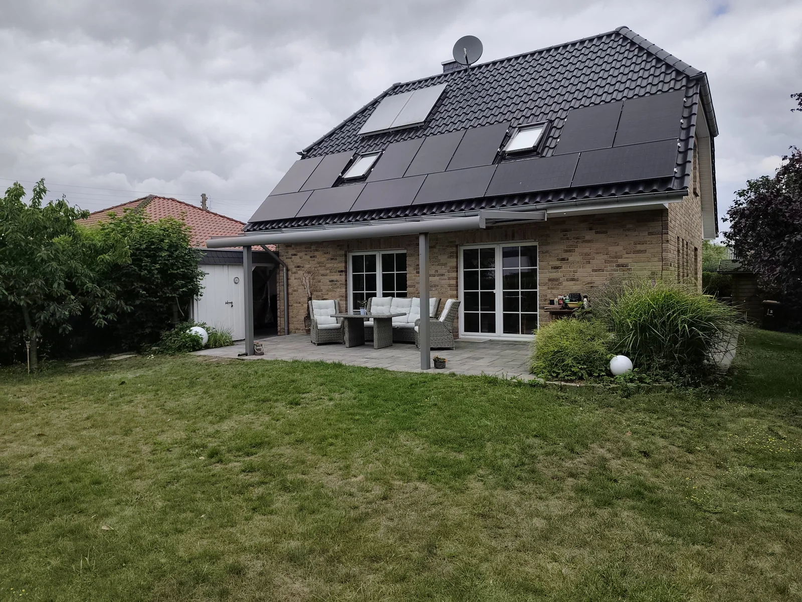 Fertiges Terrassendach in RAL 9007 am verstärkten Dachkasten eines Hauses in Berlin