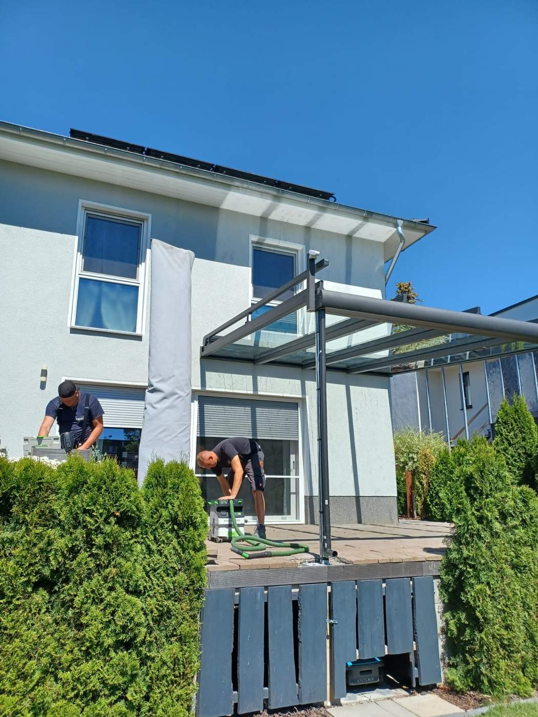 Terrassendach auf der Hochterrasse mit Blick auf die Hausfassade.