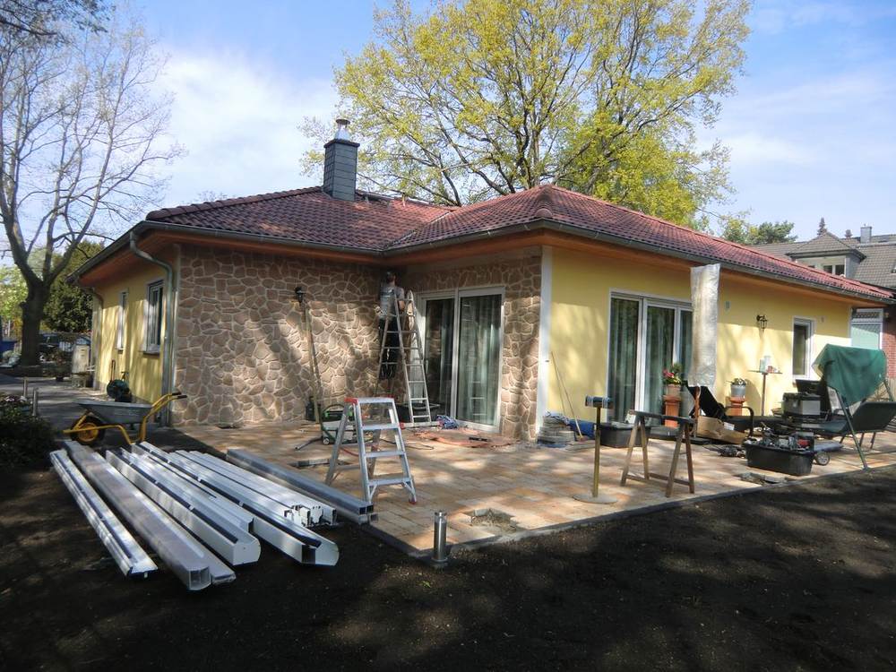 Ausgangssituation vor der Montage: Hausecke, Terrasse und angelieferte weiße Aluminiumprofile