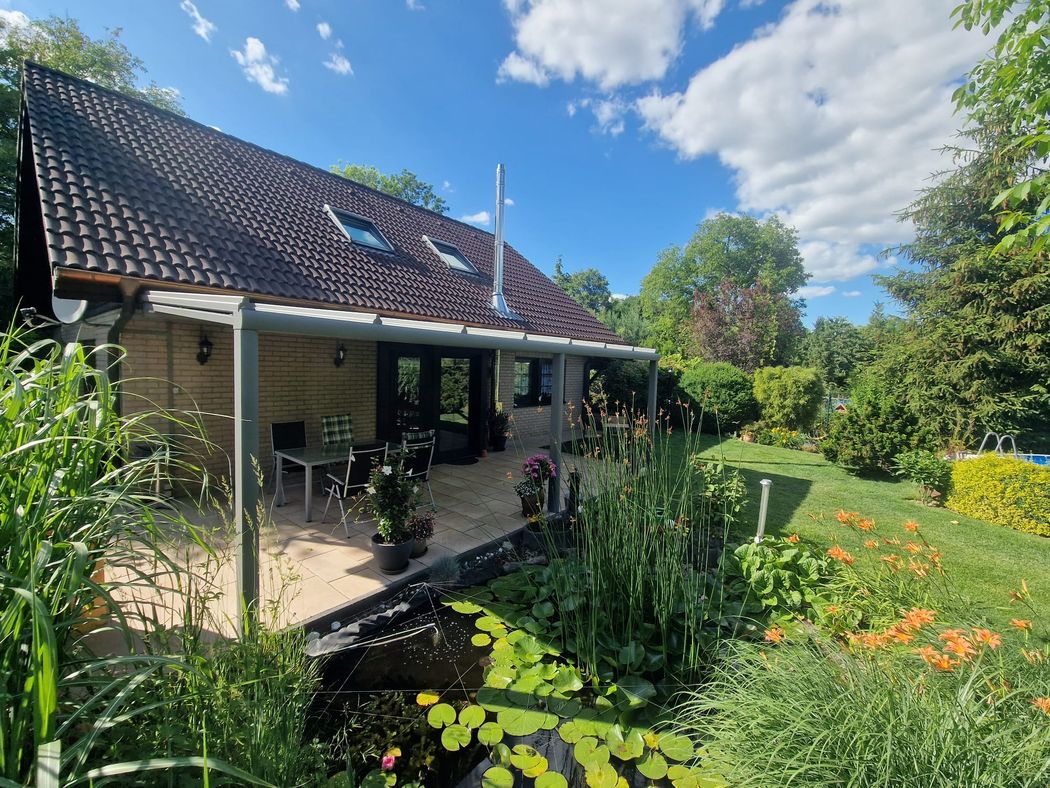 Gesamtansicht von Haus, Terrasse und Dach aus dem Garten.