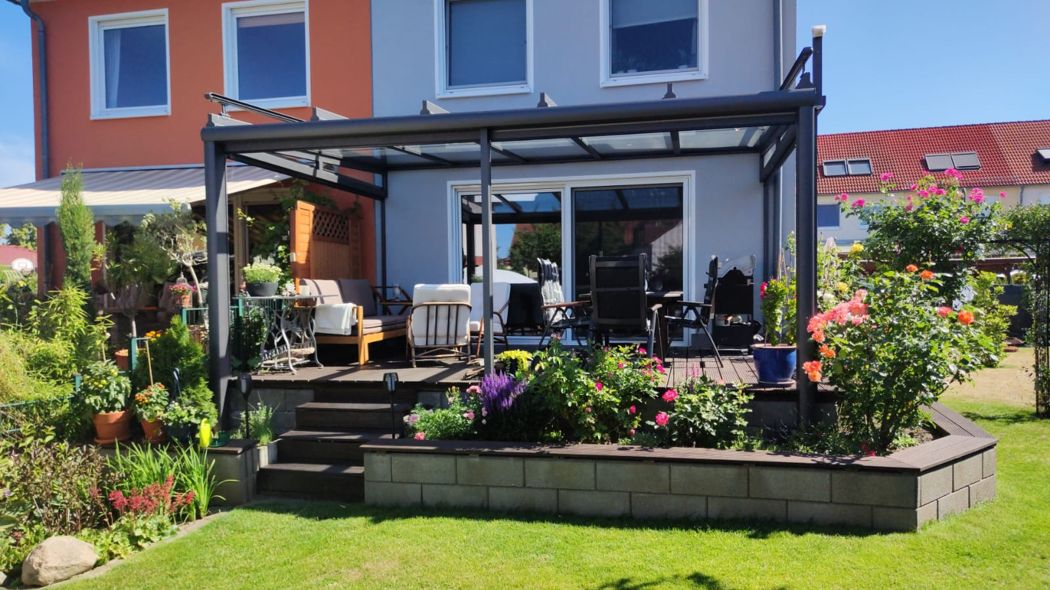 Blick von der Terrasse auf die Glasfläche und den Anschluss am Haus.
