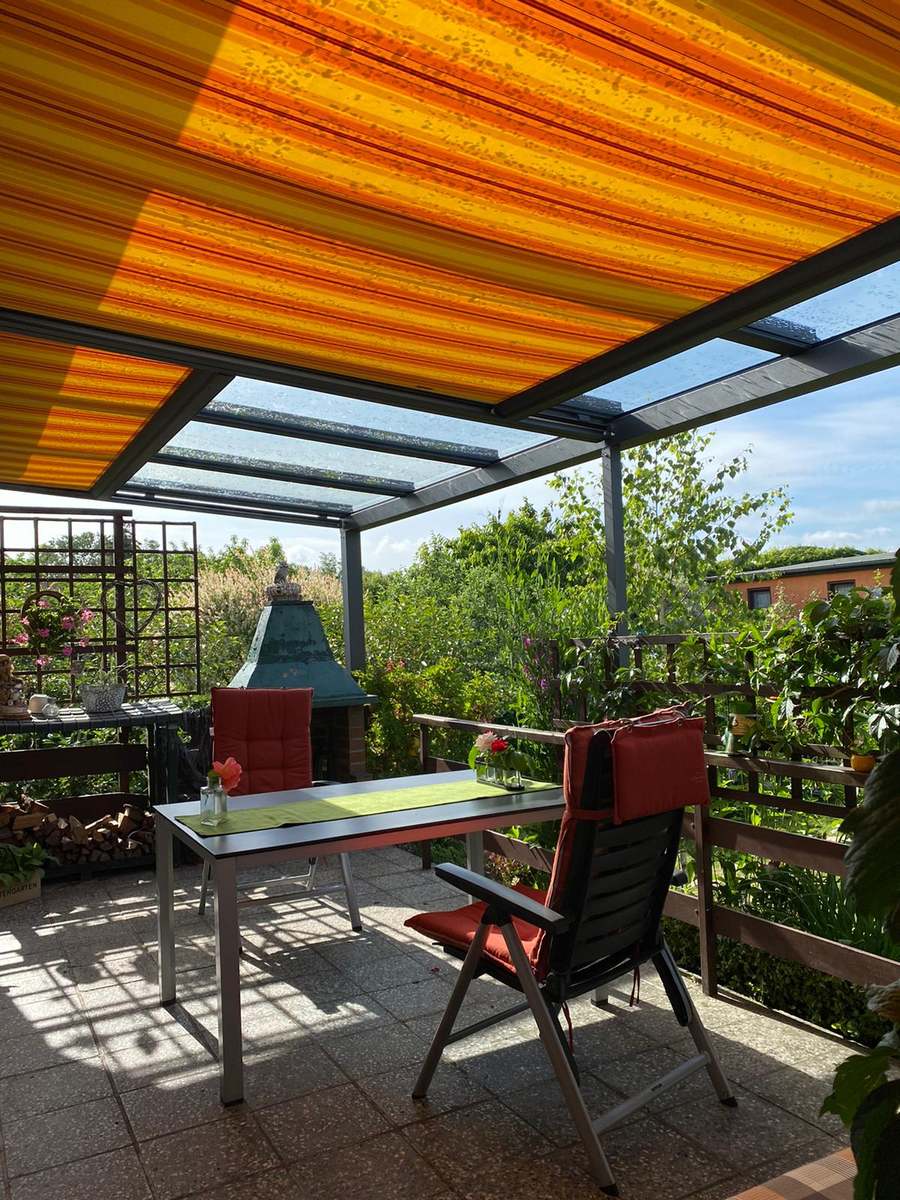 Terrasse und Sonnenschutz aus dem Garten.