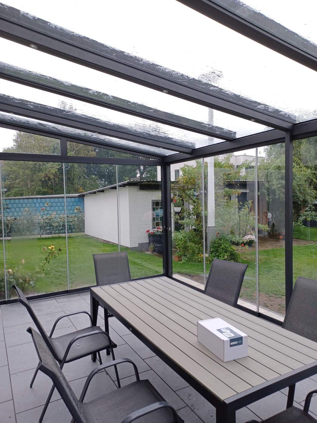 Sitzplatz unter dem Glasdach mit Blick durch die Glaswände.