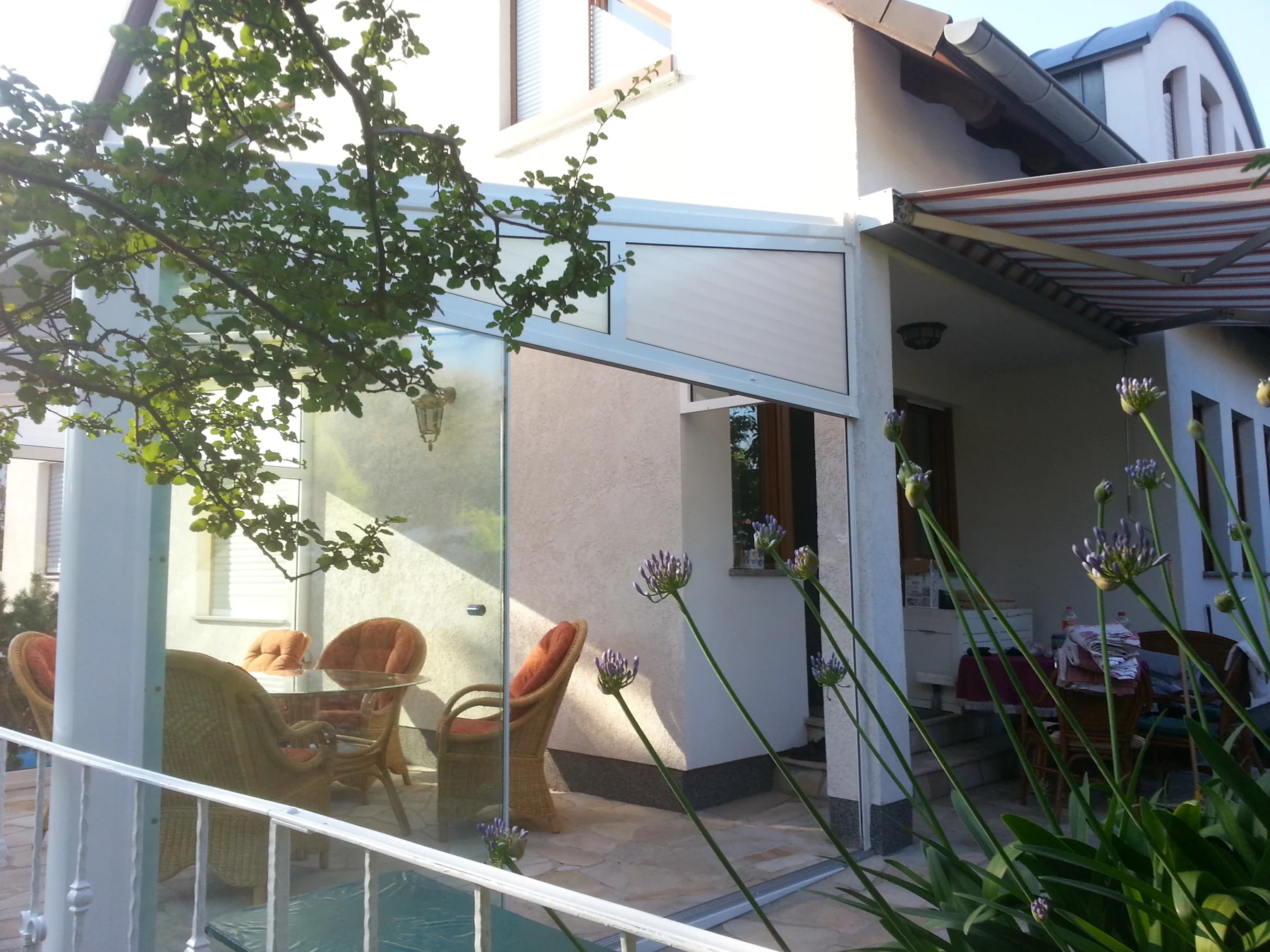 Geöffnete Glasfront am Übergang zum vorhandenen Haus.