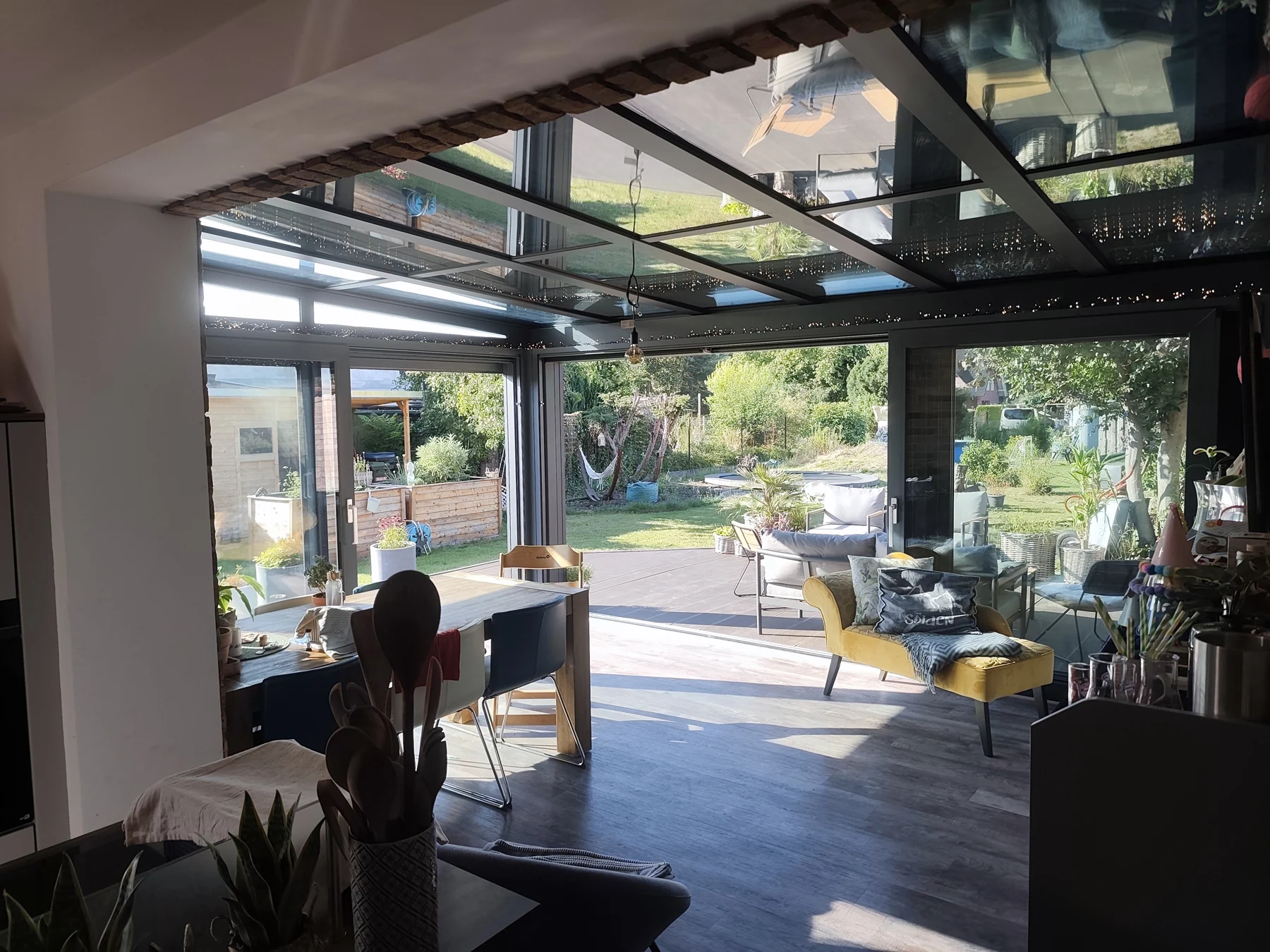 Blick vom Haus in den Wintergarten mit geöffneten Schiebeanlagen.